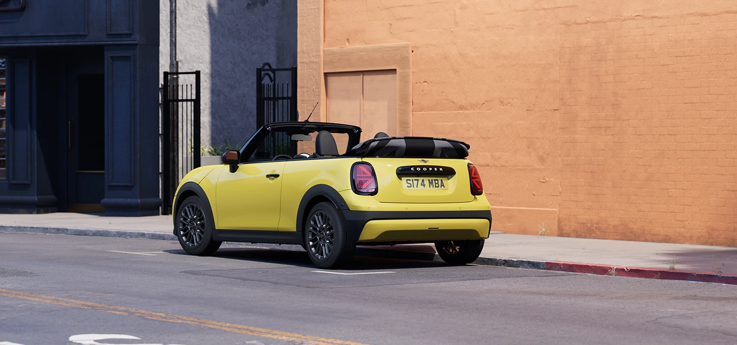 Rear left view of the MINI Cooper Convertible in Sunnyside Yellow parking.