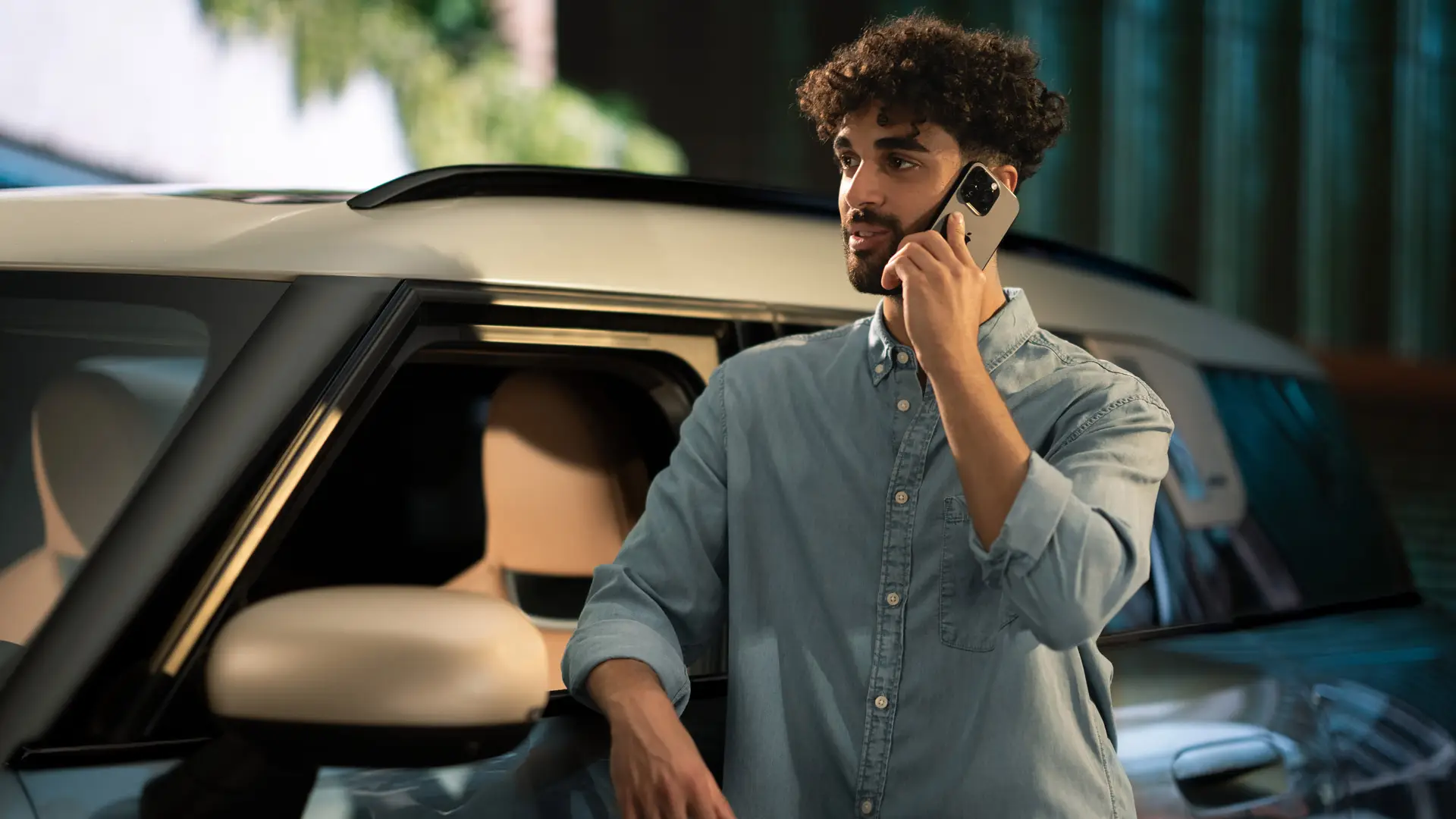 MINI Proactive Care – man stands at the side of his MINI talking on the phone to Service Centre consultant.