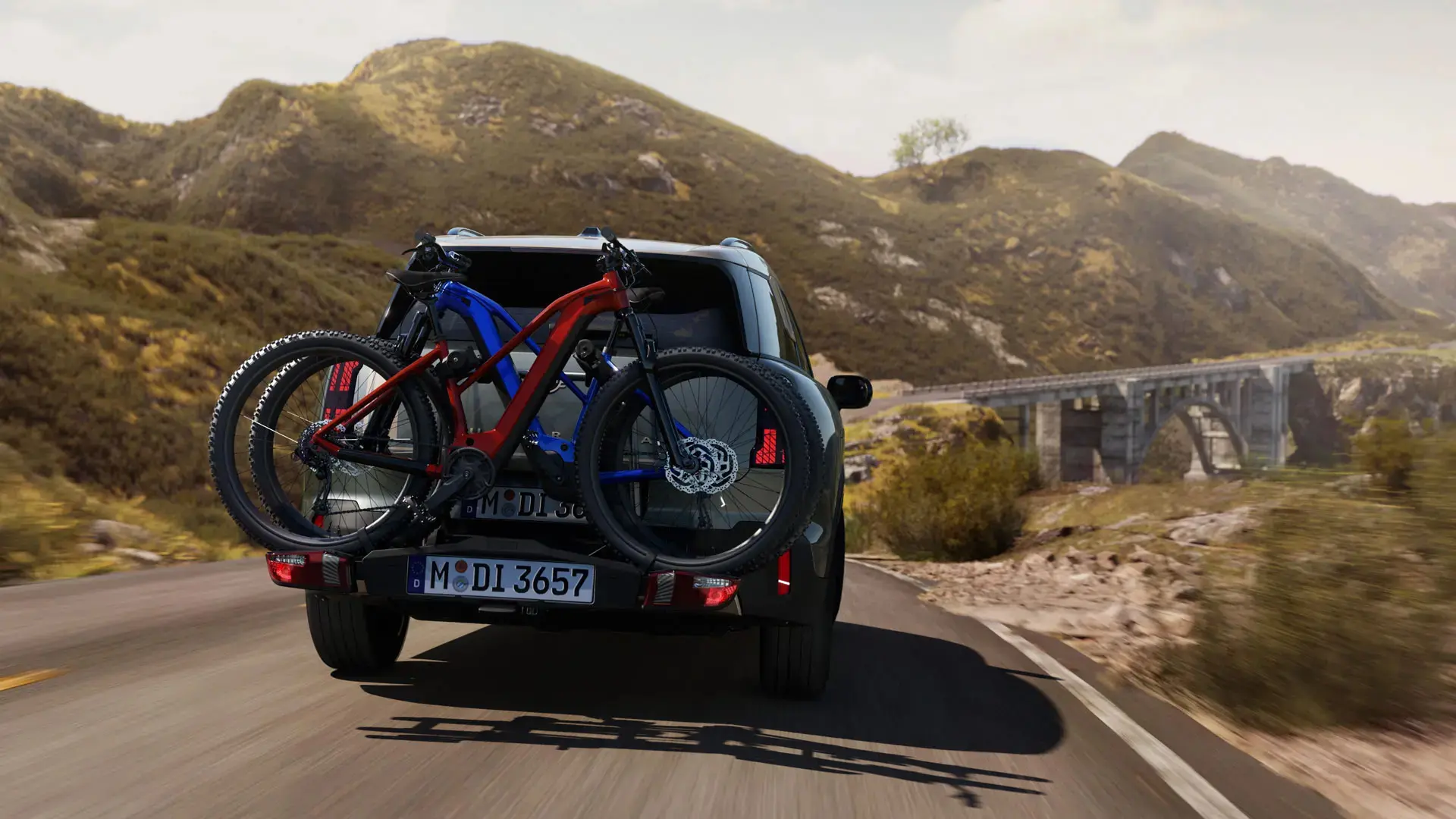 MINI Countryman Cooper in Smokey Green with MINI Rear Bike Carrier Pro 3.0 shown with two mountain bikes – rear view.
