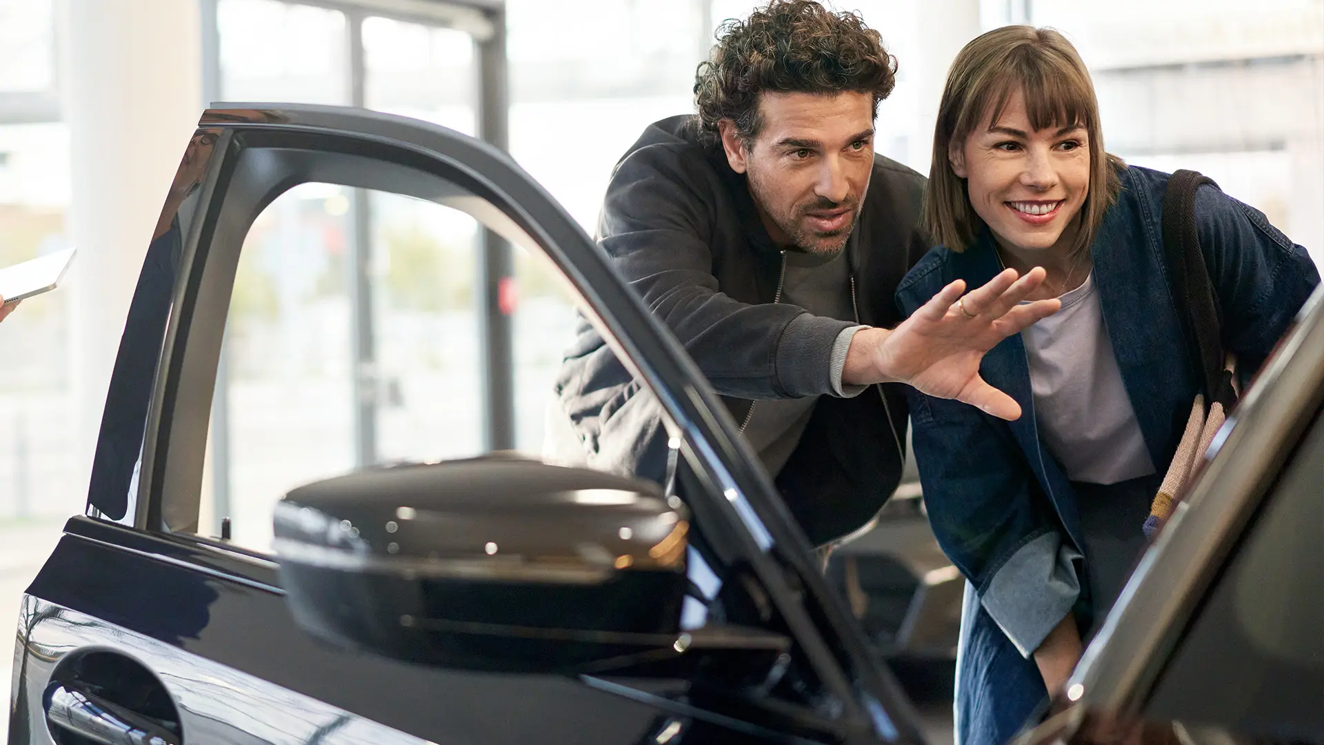 MINI inside MINI Dealership Centre with consultant advising customer and explaining interior features.