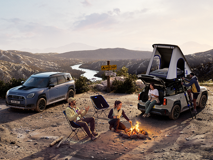 Image of two MINI Countryman Untamed Edition vehicles on a mountain in a sunset.